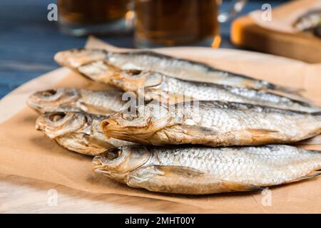 Poisson séché savoureux sur panneau de bois, gros plan Banque D'Images