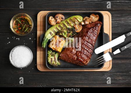 Délicieux filet de bœuf servi sur une table en bois noir, plat Banque D'Images