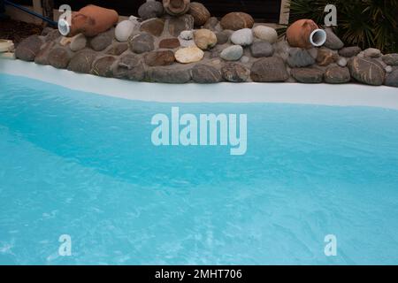 bord de la piscine avec pierre et bleu de la piscine d'eau partie de détail Banque D'Images