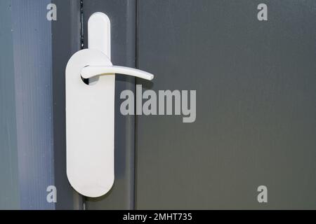 Porte-cintre blanche pour la maison sur porte classique grise avec étiquette vide ne pas déranger Banque D'Images