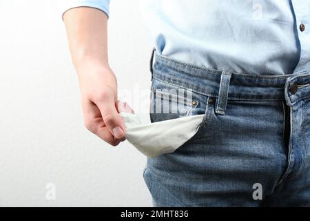 Homme montrant une poche vide sur fond clair, gros plan Banque D'Images