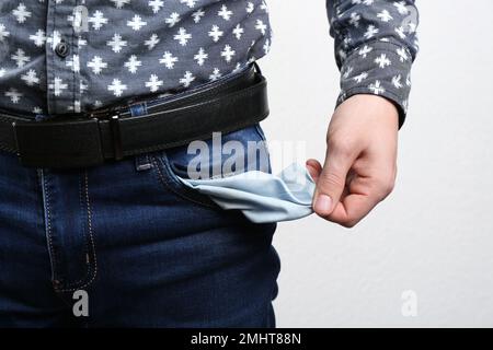 Homme montrant une poche vide sur fond clair, gros plan Banque D'Images