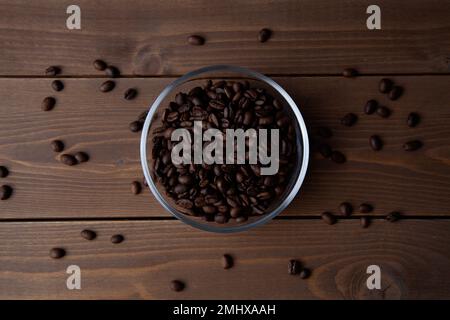 grains de café rôtis dans un bol en verre sur la table Banque D'Images