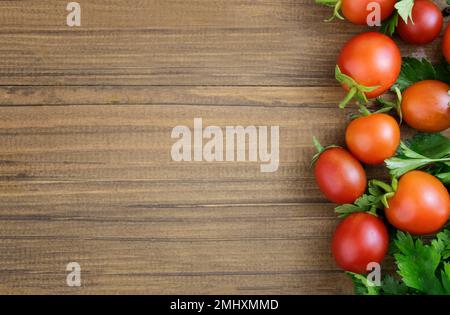 Tomates cerises sur fond de bois. Le concept de recettes avec tomates, mise en conserve. Bordure. Copier l'espace Banque D'Images