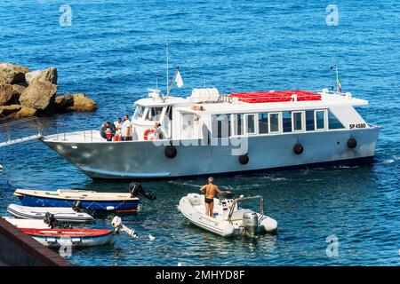 Ferry avec des touristes dans le port de l'ancien village de Tellaro lors d'une journée ensoleillée d'été, mer Méditerranée, Golfe de la Spezia, Ligurie, Italie, Europe. Banque D'Images