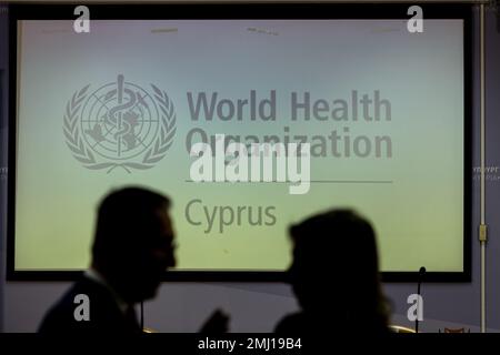 Nicosie, Chypre. 27th janvier 2023. Deux silhouettes sont visibles devant le logo DE L'OMS à l'écran, Nicosie (Chypre), le 27 janvier 2023. La signature d'un accord entre le ministère de la Santé, représenté par le ministre de la Santé, M. Michalis Hadjipantela, Et l'Organisation mondiale de la santé, représentée par le Directeur régional DE L'OMS, Dr. Hans Henri P. Kluge, pour l'ouverture d'un bureau de pays à Larnaka, a lieu aujourd'hui au Ministère de la Santé. (Photo de Kostas Pikoulas/Sipa USA) crédit: SIPA USA/Alay Live News Banque D'Images