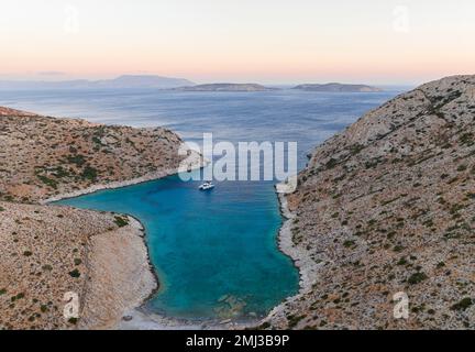 Catamaran à voile dans une baie de l'île de Levitha, île grecque, Mer Egéé du Sud, Grèce Banque D'Images