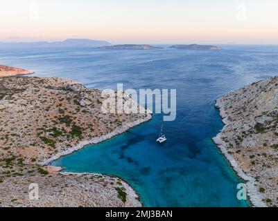 Catamaran à voile dans une baie de l'île de Levitha, île grecque, Mer Egéé du Sud, Grèce Banque D'Images