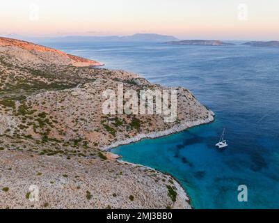 Catamaran à voile dans une baie de l'île de Levitha, île grecque, Mer Egéé du Sud, Grèce Banque D'Images