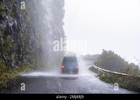 Cascata dos Anjos, VW bus conduit par une cascade sur la route, Madère, Portugal Banque D'Images