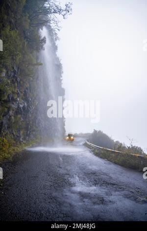 Cascata dos Anjos, VW bus conduit par une cascade sur la route, Madère, Portugal Banque D'Images