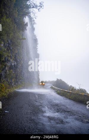 Cascata dos Anjos, VW bus conduit par une cascade sur la route, Madère, Portugal Banque D'Images