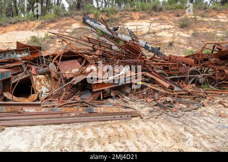 Photographie de pièces de train anciennes et rouillées et de métal qui ont été laissés dormants sur le sol dans une forêt Banque D'Images