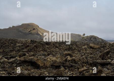Vieux cône volcanique entouré de lave à Tinajo, Lanzarote Banque D'Images