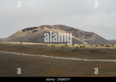 Vieux cône volcanique entouré de lave à Tinajo, Lanzarote Banque D'Images