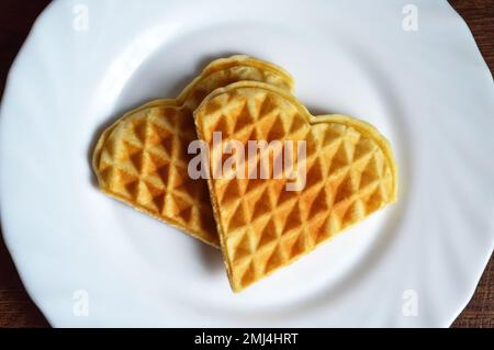 Gaufres en forme de cœur sur l'assiette. Petit déjeuner de la Saint-Valentin. Concept Flat Lay Love. Banque D'Images