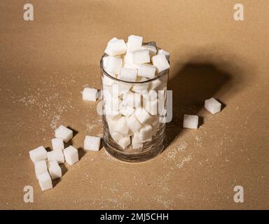 Surconsommation de sucre, addiction concept. Morceaux raffinés de morceaux doux blancs en verre. Photo de haute qualité Banque D'Images