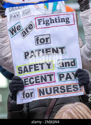 Grève des infirmières portant des panneaux, manifestant devant l'entrée de l'hôpital universitaire de Londres, pour protester contre les réductions gouvernementales et les salaires injustes. Banque D'Images