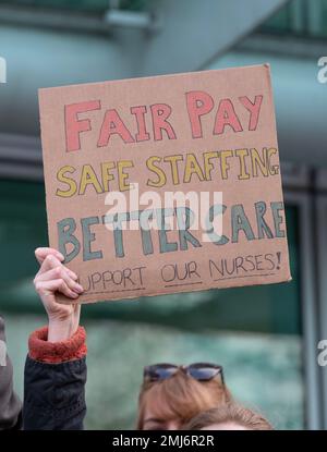 Grève des infirmières portant des panneaux, manifestant devant l'entrée de l'hôpital universitaire de Londres, pour protester contre les réductions gouvernementales et les salaires injustes. Banque D'Images