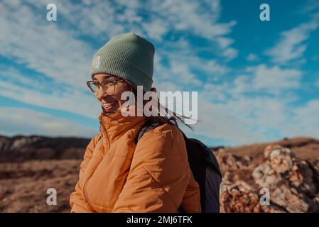 Femme voyageur libre assise au sommet des montagnes et profiter d'une nature merveilleuse. Yound Girl sur la montagne de pic avec une vue parfaite montagnes enneigées Banque D'Images