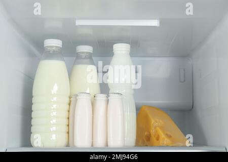 Bouteilles de produits laitiers sur la tablette du réfrigérateur Banque D'Images