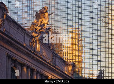 Les statues emblématiques de Grand Central terminal et l'horloge au-dessus de l'entrée de 42nd Street brillent d'or à l'aube, sur fond de Hyatt Grand Central New York. Banque D'Images