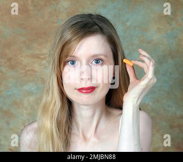 Jeune femme tenant le bouchon d'oreille en mousse prêt à l'emploi contre la pollution sonore Banque D'Images