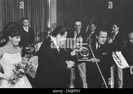 Pays-Bas Histoire: Le chanteur allemand Gerard Wendlang reçoit un record d'or au Casino pour son "Tanze mit mir in den Morgen". Mlle World Rina Lodders remet le record de l'or; Date: 27 septembre 1962 Banque D'Images