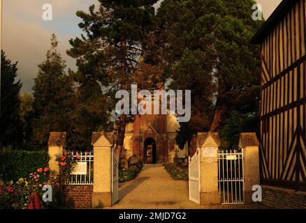 Église Saint-Martin de Beuvron-en-Auge baignée par la lumière du soleil de la fin de l'après-midi en Normandie, en France, lors D'Une belle Journée d'été ensoleillée avec quelques nuages en T Banque D'Images