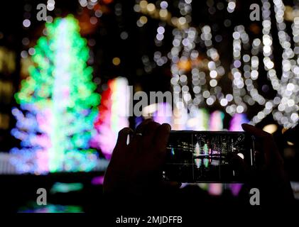 (230128) -- LONDRES, le 28 janvier 2023 (Xinhua) -- Un visiteur prend des photos lors d'un spectacle de lumière d'hiver à Canary Wharf à Londres, en Grande-Bretagne, le 27 janvier 2023. (Xinhua/Li Ying) Banque D'Images