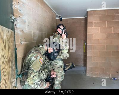 Les soldats enfilent leur masque protecteur après avoir effacé une pièce et remarqué que le « gaz » se trouve dans la pièce. Le défrichement d'une salle était l'une des voies que les ingénieurs devaient terminer pendant les piquets de sapeurs à Camp Dodge, Iowa, du 27 au 28 août. Banque D'Images