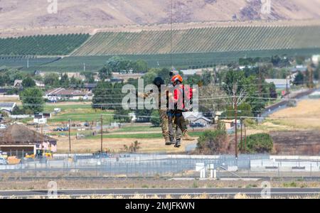 Un soldat affecté aux États-Unis Le détachement d'ambulance aérienne de l'Armée de terre- le centre d'entraînement de Yakima est hissé dans un hélicoptère UH-60L Black Hawk avec un membre du Central Washington Mountain Rescue au centre d'entraînement de Yakima, Washington, le 28 août 2022. Banque D'Images