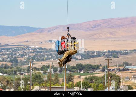 Un soldat affecté aux États-Unis Le détachement d'ambulance aérienne de l'Armée de terre- le centre d'entraînement de Yakima est hissé dans un hélicoptère UH-60L Black Hawk avec un membre du Central Washington Mountain Rescue au centre d'entraînement de Yakima, Washington, le 28 août 2022. Banque D'Images