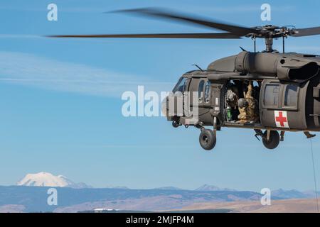 Un CHEF d'équipe UH-60L Black Hawk affecté aux États-Unis Détachement d'ambulance aérienne de l'Armée de terre-Yakima, 2-158 Bataillon d'hélicoptères d'assaut, 16th Brigade d'aviation de combat regarde l'hélicoptère pendant l'entraînement au Centre d'entraînement de Yakima, Washington, le 28 août 2022. USAAAD-YTC est responsable de la couverture d'évacuation aéromédicale du centre de formation de Yakima, en plus de soutenir les autorités civiles locales dans le centre de Washington. Banque D'Images