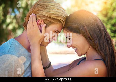 L'amour - quel beau sentiment. un jeune couple affectueux qui partage un moment de tendresse en plein air. Banque D'Images