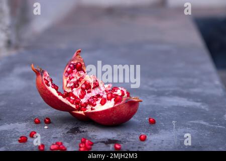 Fruits mûrs à la grenade avec graines sur fond sombre Banque D'Images