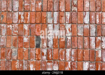 Un gros plan d'un mur de briques rouges abîmé. Banque D'Images