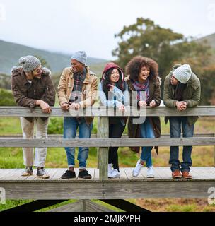 Le temps que vous aimez perdre n'est jamais vraiment perdu. un groupe d'amis accrochant ensemble sur un pont en bois. Banque D'Images