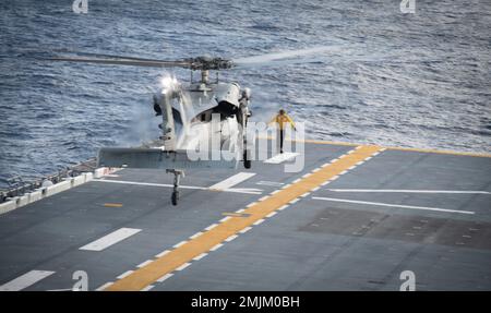 MER DE CHINE ORIENTALE (31 août 2022) un hélicoptère MH-60s Sea Hawk, du détachement 6 de l'Escadron de combat de la mer (HSC) 25, débarque sur le pont de vol du transporteur d'assaut amphibie déployé par l'avant USS America (LHA 6) pendant les opérations de vol en mer de Chine orientale, le 31 août 2022. L'Amérique, navire chef de file du America Amphiobie Ready Group, opère dans la zone d'opérations 7th de la flotte pour améliorer l'interopérabilité avec ses alliés et ses partenaires et servir de force de réaction prête à l'emploi pour défendre la paix et la stabilité dans la région Indo-Pacifique. Banque D'Images