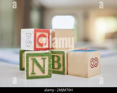 Blocs en bois, table et lettres pour l'apprentissage, l'éducation ou le développement de l'enfance à la maison. Jouets cubes en bois colorés pour apprendre des chiffres ou de l'alphabet pour Banque D'Images