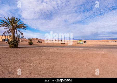 Paysage infini dans le désert au Maroc avec des objets dispersés le long du sol Banque D'Images