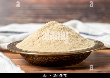 Piment blanc en poudre. Grains de poivre blanc moulu en poudre dans un bol sur fond de bois. Concept d'épices sèches. gros plan Banque D'Images
