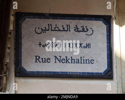 Un petit panneau de rue trilingue arabe français et berbère à Fès médina médiévale (vieille ville). Maroc. Banque D'Images