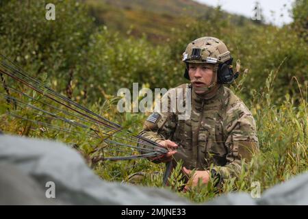 Un spécialiste du parti tactique de contrôle aérien de la Force aérienne, affecté au détachement 1, 3rd, Escadron des opérations de soutien aérien, récupère son parachute après son atterrissage dans la zone de chute de Geronimo, base interarmées Elmendorf-Richardson, Alaska, le 31 août 2022. Les aviateurs et les parachutistes de la Force aérienne, appuyés par l'équipage de la Garde nationale de l'Armée de l'Alaska du Commandement de la troupe d'aviation de 207th, ont mené l'entraînement pour démontrer les compétences aéroportées et de préparation à la mission dans des conditions austères. Banque D'Images