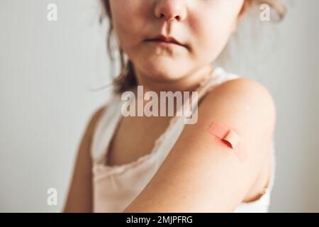 Petite fille sensation de douleur ayant quelques effets secondaires après la vaccination. Rougeur, enflure, membres de la douleur et maux de tête comme réaction après la vaccination. Getti Banque D'Images