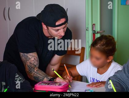 L'aviateur Mitchell Shoemake, bénévole du programme d'enseignement de l'anglais Vicini americani, aide un enfant italien avec une activité en anglais au camp d'été Giovani in Movimento à Aviano, Italie, 31 août 2022. Pendant les camps d’été, plus de 45 bénévoles ont interagi avec les enfants dans le cadre de différentes activités et ateliers qui ont contribué à améliorer les compétences en anglais et en communication des enfants. 31 FW, Communauté, Programme d'enseignement de l'anglais, Vicini americani, bénévole, Banque D'Images
