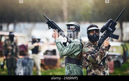 Paintball, prêt ou des personnes dans un jeu de tir d'arme à feu avec action de guerre dans le terrain de jeu champ de bataille en vacances. Mission militaire, équipe ou joueurs avec Banque D'Images