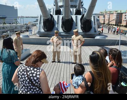 Norfolk, Virginie (1 septembre 2022). Le lieutenant Aaron Antonio, affecté au quai de transport amphibie de la classe San Antonio USS New York (LPD 21), parle à des membres de sa famille avant sa promotion au Lieutenant Commander. La cérémonie s'est déroulée à bord du cuirassé de classe Iowa USS Wisconsin (BB 64). La cérémonie a été organisée et coordonnée par le Hampton Roads Naval Museum, un des dix États-Unis Musées de la Marine au sein du Commandement de l'histoire et du patrimoine de la Marine. Le musée offre des cérémonies militaires pour les commandements de zone sans frais dans le cadre de leurs offres de sensibilisation militaire. Banque D'Images