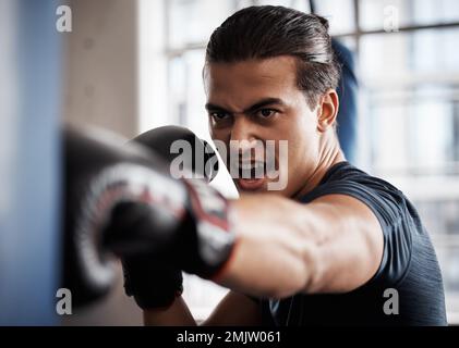 Boxeur, sport et homme avec sac de poinçonnage pour l'entraînement de fitness, de combat exercice de gym ou de défi de puissance intense. Athlète fort, combattant en colère ou personne Banque D'Images