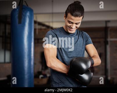 Fitness, boxe et homme avec des gants dans la salle de gym pour l'entraînement sportif, l'exercice ou le défi. Heureux, sourire et athlète ou boxeur de sexe masculin faisant de la kickboxing cardio Banque D'Images